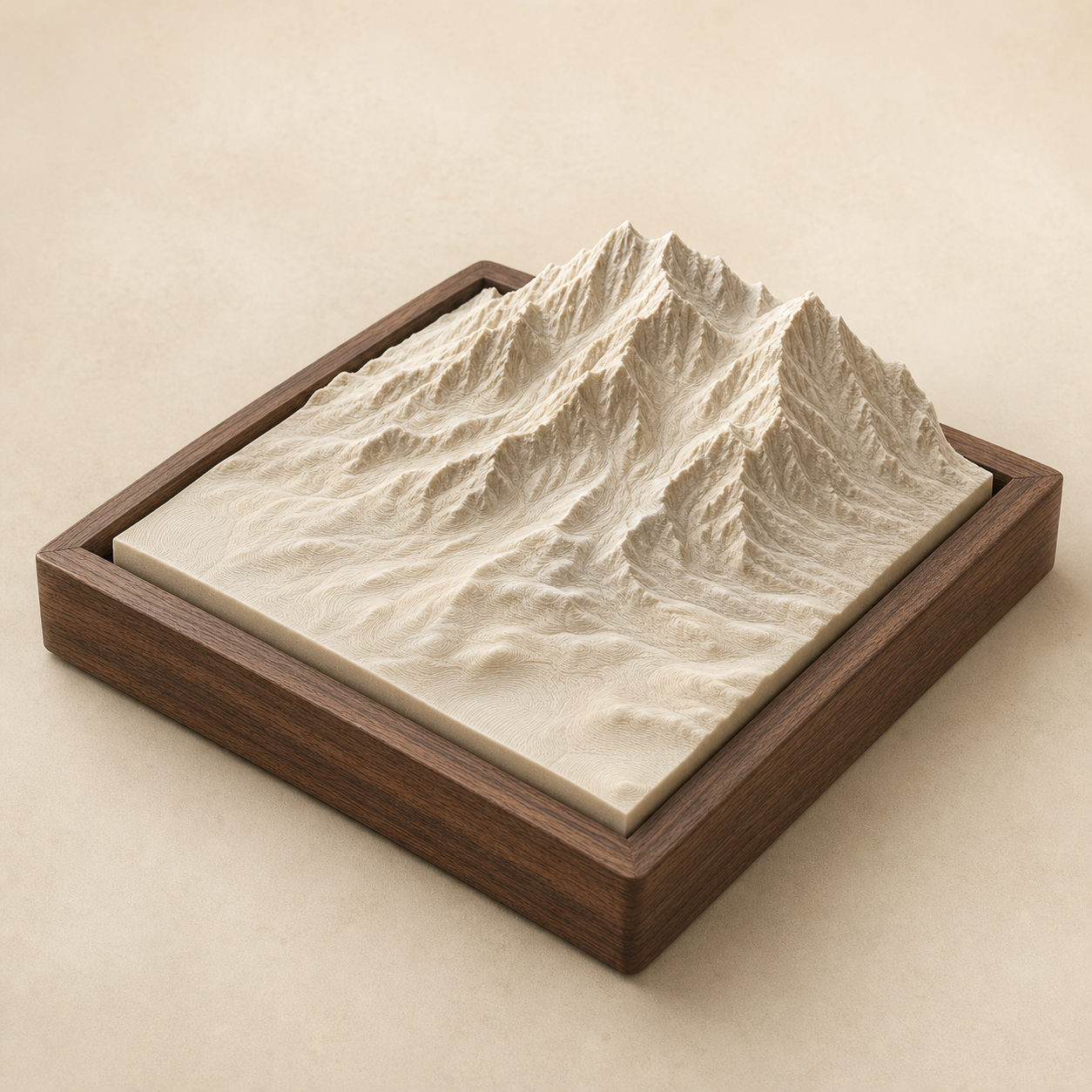 An ivory terrain model in a walnut frame with dramatic mountain relief